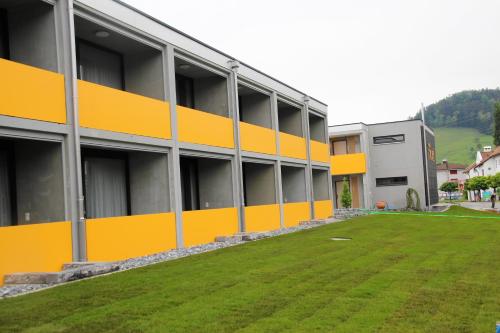 a large building with a grass yard in front of it at wohnMOTEL - Hinterforst in Altstätten