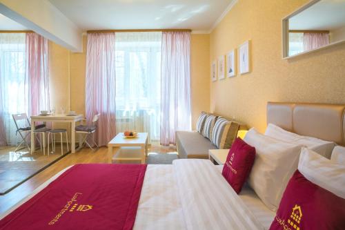モスクワにあるLux-Apartments, улица Заморенова 14のベッドとリビングルームが備わるホテルルームです。