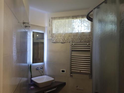 ein Bad mit einem Waschbecken und einem Fenster in der Unterkunft Villa Talciona in Poggibonsi