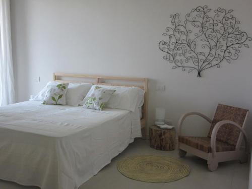 una camera con letto, sedia e lampadario a braccio di Venezia nature&beach a Cavallino-Treporti