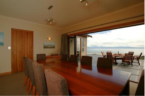 a dining room with a large wooden table and chairs at Parautane Lodge in Nelson
