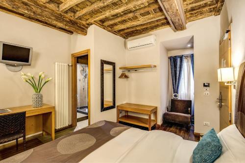 Dormitorio con cama, escritorio y TV en Trevi Beau Boutique Hotel, en Roma