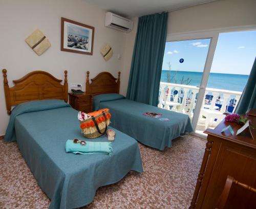 sypialnia z 2 łóżkami i widokiem na ocean w obiekcie Hotel Mediterraneo Carihuela w mieście Torremolinos