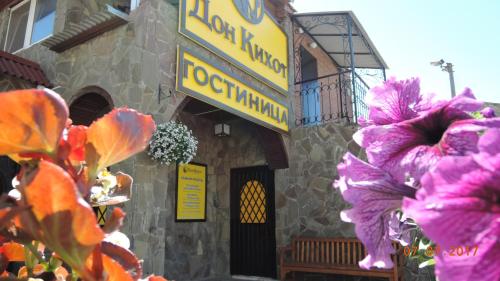 a restaurant with purple flowers in front of a building at Don Kihot Mini-Hotel in Tolyatti