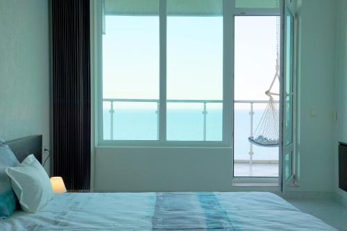 a bedroom with a bed and a window with a hammock at Silver Beach Delux Apartment in Byala