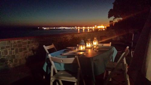 a table with chairs sitting on a wall with the ocean at La Terrazza nel Mare in Acciaroli