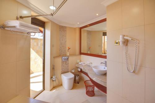 a bathroom with a sink and a toilet and a mirror at Enashipai Resort & Spa in Naivasha