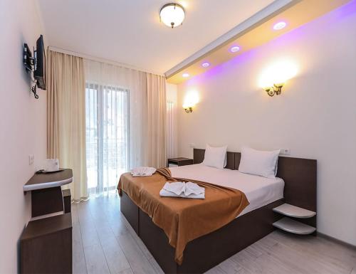 a hotel room with a bed and a large window at Hotel Holiday Maria in Băile Herculane