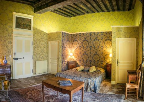 a bedroom with a bed and a table at Chambres d'hôtes au Château de Gizeux in Gizeux