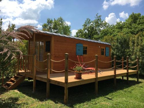 a wooden cabin on a deck in the grass at Coutillard in Parisot-Tarn-et-Garonne