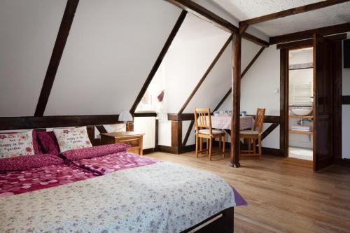 a bedroom with a bed and a table and chairs at Gospodarstwo Agroturystyczne Kowalowe Wzgórze in Polanica-Zdrój