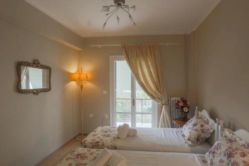 a bedroom with a bed and a window at Mon Repos deluxe apartment in Corfu