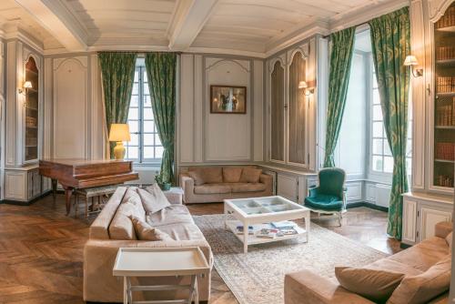 a living room with a couch and a piano at Chambres d'hôtes au Château de Gizeux in Gizeux