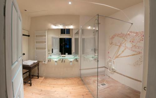 a bathroom with two sinks and a glass shower at Chambres d'hôtes au Château de Gizeux in Gizeux
