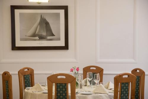 a table with chairs and a picture of a boat at Hotel Villa Maria in Sorrento