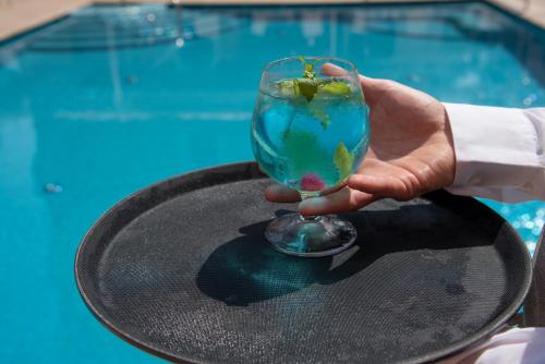 a hand holding a glass with a ball on a table at Hotel Villa Maria in Sorrento
