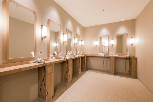 Baño con una fila de lavabos y espejos en HOTEL MYSTAYS PREMIER Sapporo Park, en Sapporo