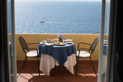 a table with food on it with the ocean in the background at Hotel Weber Ambassador in Capri