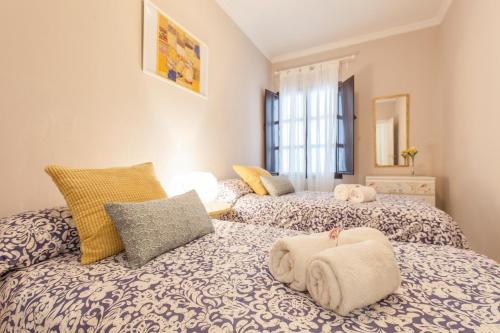 sypialnia z 2 łóżkami i ręcznikami w obiekcie Elegante apartamento en el corazon de Sevilla. w Sewilli