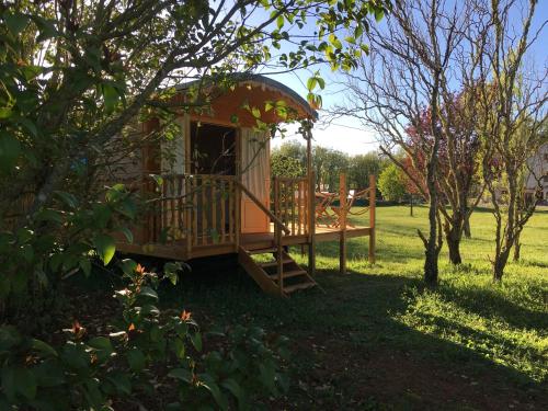 a tree house with a porch and a swing at Coutillard in Parisot-Tarn-et-Garonne