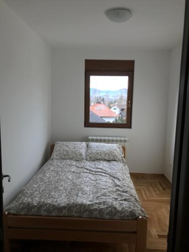 a bed in a room with a window at Apartment Gaj in Zlatibor