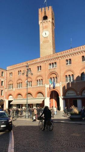 a person riding a bike in front of a building with a clock tower at Palazzina300 in Treviso