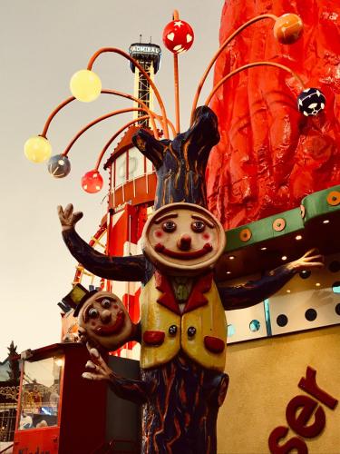 a statue of two people standing in front of a carnival ride at Best Place Apartments Vienna in Vienna