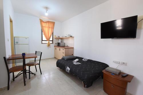 a bedroom with a bed and a table with a tableablish at Flintstone Guest House בית ההארחה בן 11 החדרים אינו וילה פרטית אתם מזמינים רק חדרים לא את כל הוילה in Eilat