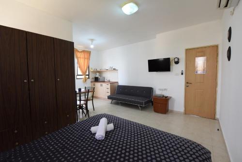 a bedroom with a bed with a white cross on it at Flintstone Guest House בית ההארחה בן 11 החדרים אינו וילה פרטית אתם מזמינים רק חדרים לא את כל הוילה in Eilat