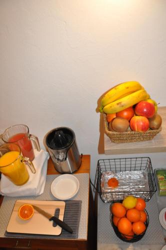 a table with a bowl of fruit and a basket of oranges at Europe Hotel Vieux Port in Marseille