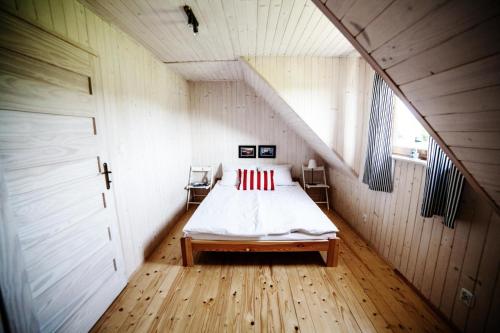 Dormitorio pequeño con cama en el ático en Morskie Zacisze Jarosławiec en Jarosławiec