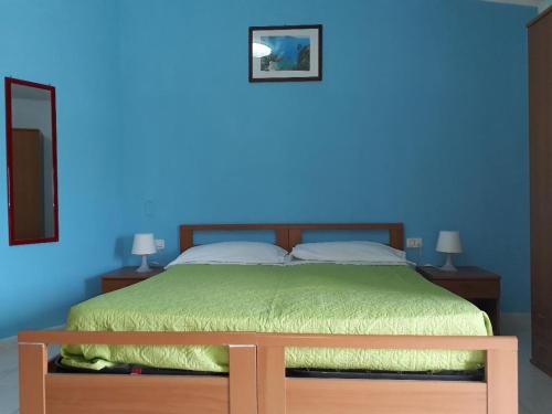 a bedroom with a bed with a blue wall at Pensione Nettuno in Palinuro