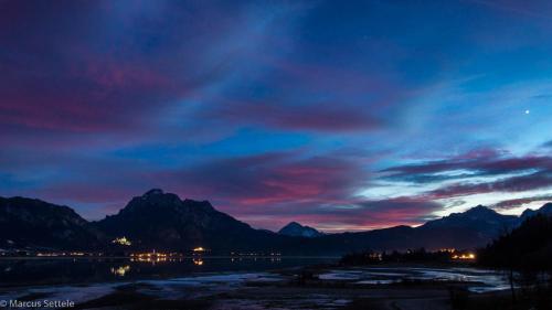 a sunset over the mountains and a body of water at Cafe Maria - Pension - B&B in Rieden am Forggensee