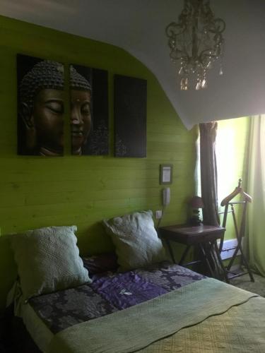 a bedroom with a headboard with a large headrait on the wall at Hôtel Boutique Saint-Louis in Lisieux