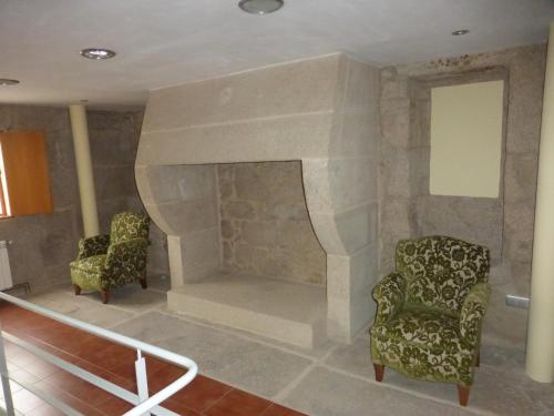 a living room with two chairs and a fireplace at Casa Bravo in Gondomar
