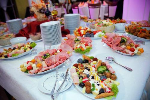 uma mesa com muitos pratos de comida em Hotel Holiday Maria em Băile Herculane