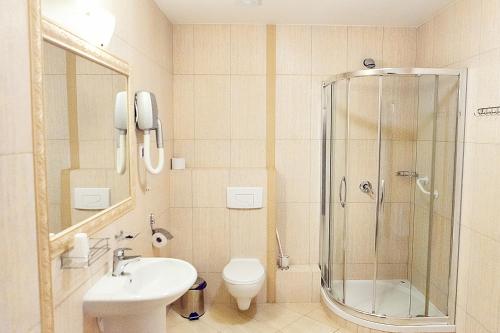 a bathroom with a shower and a toilet and a sink at Hotel Lord Dębica in Dębica