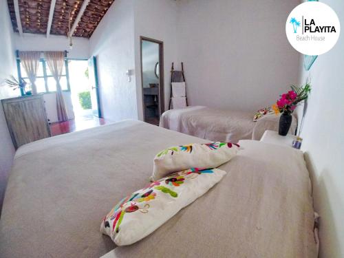 1 dormitorio con 2 camas con almohadas en La Playita Beach House, en Puerto Escondido