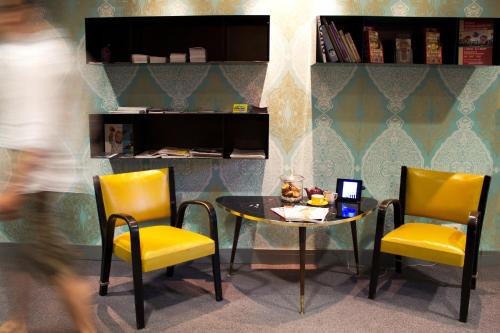 a table and two yellow chairs and a table and chairs at Saint SHERMIN bed breakfast & champagne in Vienna