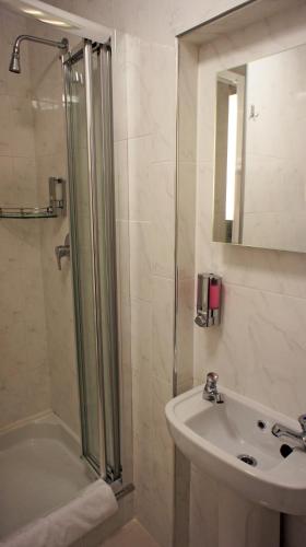 a bathroom with a shower and a sink at Abbey Court Hotel - Hyde Park in London