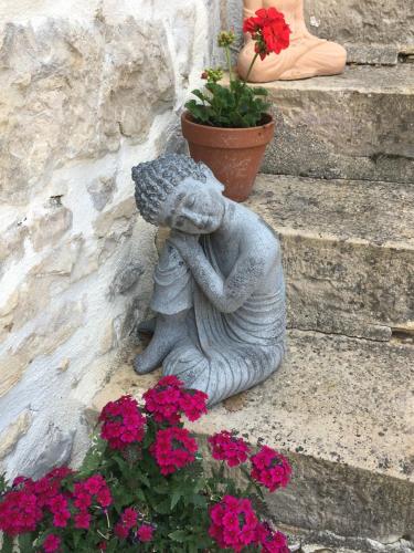a statue of a squirrel sitting on the steps with flowers at Coutillard in Parisot-Tarn-et-Garonne