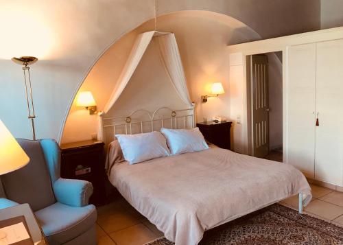 a bedroom with a large bed and a chair at Economou Mansion in Spetses