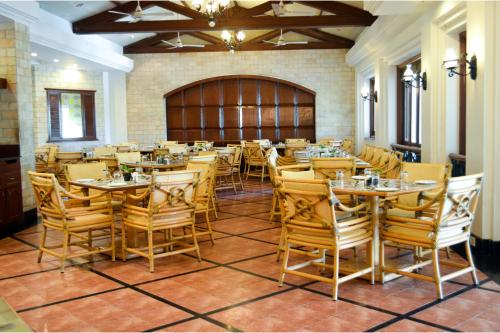 een grote eetkamer met tafels en stoelen bij The Lagoona Resort in Lonavala