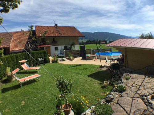 podwórko ze stołem i krzesłami oraz dom w obiekcie Ferienhof Prinz w mieście Oberreute