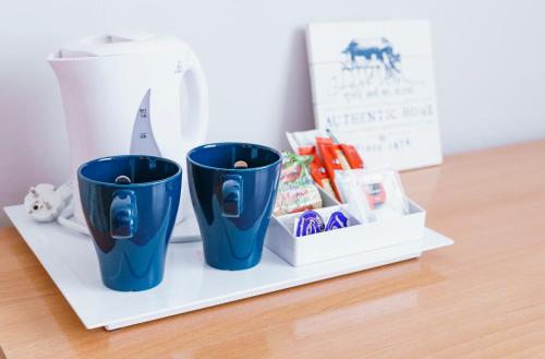 two blue cups sitting on a white shelf at BYPILLOW Mumm in Vilanova i la Geltrú