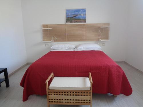 ein Schlafzimmer mit einem Bett mit einer roten Decke und einem Stuhl in der Unterkunft Eryx Apartments in Trapani