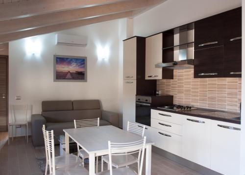 eine Küche und ein Esszimmer mit Tisch und Stühlen in der Unterkunft Casa vacanza Leucosia&Tresino in Santa Maria di Castellabate