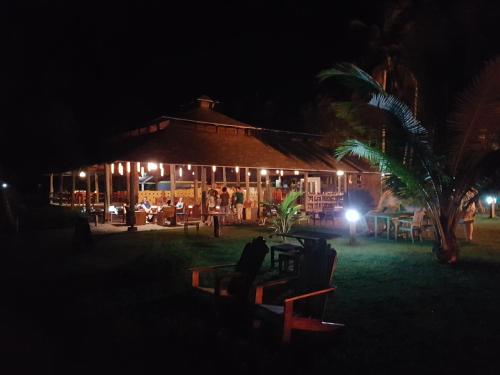 a man sitting on a bench in front of a building at night at Ko-Sa Beach Resort Ltd in Ampeni