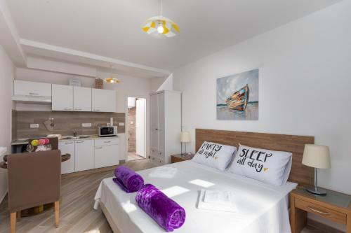 a bedroom with a large bed with purple pillows on it at Apartment Jasmina in Dubrovnik