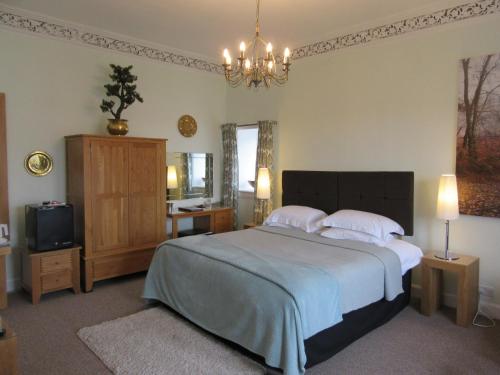 1 dormitorio con 1 cama grande y TV en Middleton House Bed and Breakfast en Auchterarder